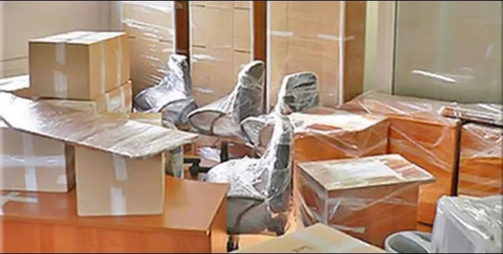 مكتب بكراسي مغلفة بالنايلون وكراتين أثناء نقل المكتب
