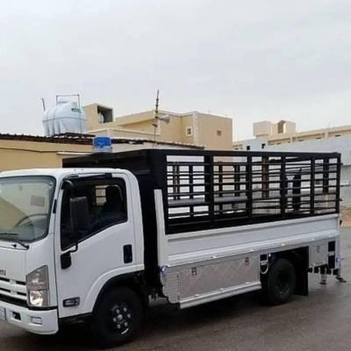 شاحنة نقل بيضاء بصندوق مسيج متوقفة في حي سكني