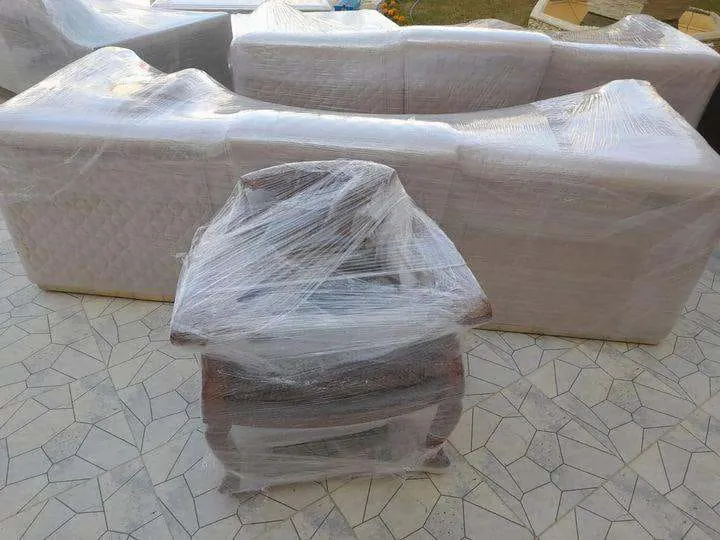 كنبة وكرسي مغلفان بالنايلون الشفاف على أرضية فسيفساء